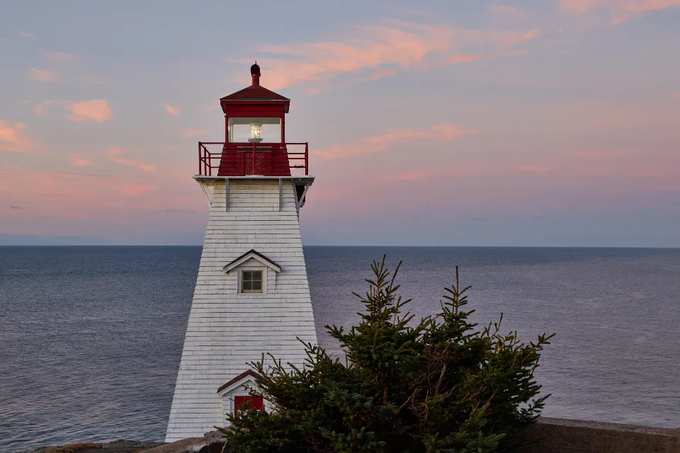 Farol branco junto ao oceano Atlântico sob céu azul