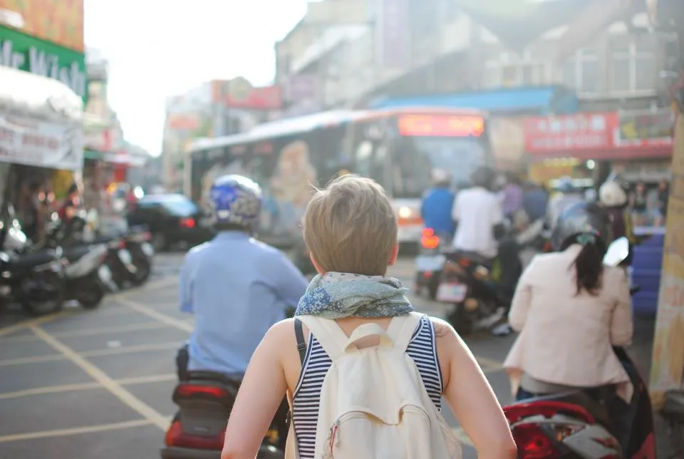 Scooters e motos no trânsito de uma rua movimentada
