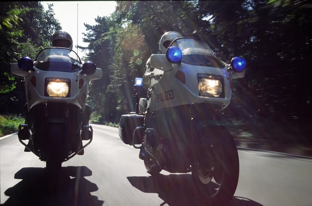 Dois motociclistas a circular numa estrada ao fim da tarde